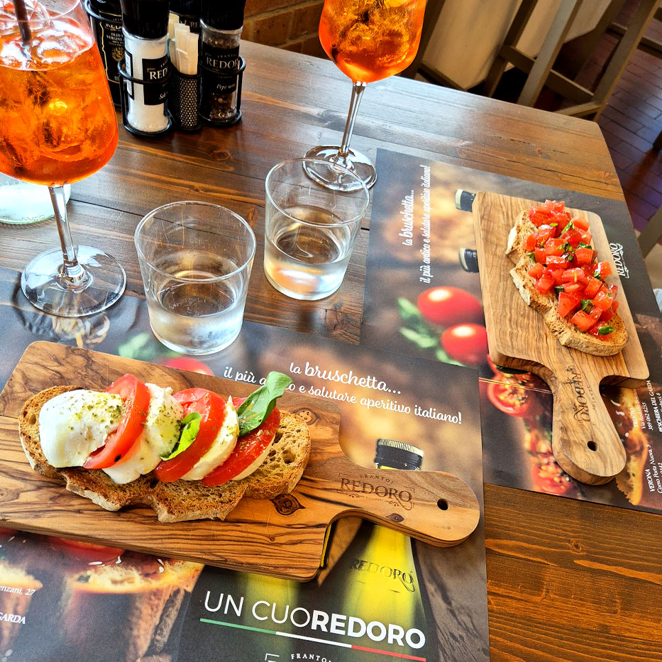 Due bruschette con ingredienti freschi e due spritz, specialità della Bruschetteria Redoro al ristorante Il Piccolo Mondo Redoro.