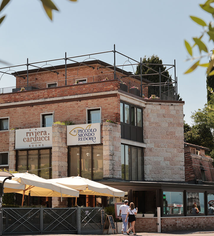 Esterno del ristorante Il Piccolo Mondo Redoro a Peschiera del Garda, con vista sul Lago e mura veneziane.