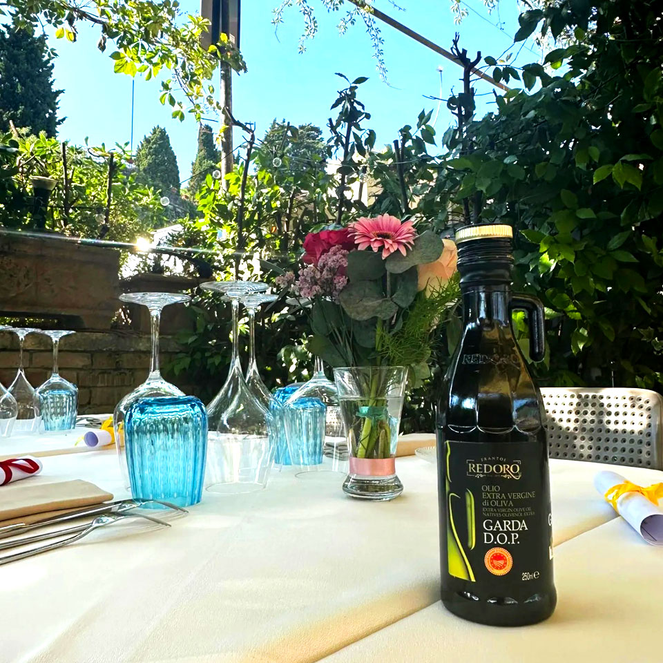 avolo all'aperto nel giardino del ristorante Il Piccolo Mondo Redoro a Peschiera del Garda, pronto per una cena indimenticabile.